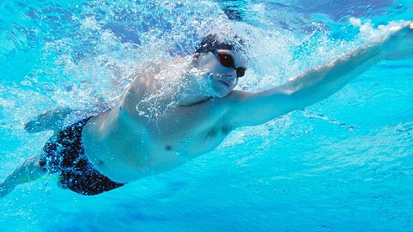 What are the benefits and drawbacks of swimming on an empty stomach